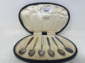 A set of six Edwardian silver and coloured enamel teaspoons, Birmingham 1902, in a Barraclough
