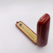 An early 20th century diamond and ruby stick pin, in a vintage jewellery box Provenance: From a