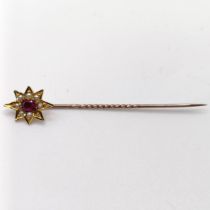 An early 20th century silver coloured metal, yellow coloured metal, ruby and seed pearl stick pin