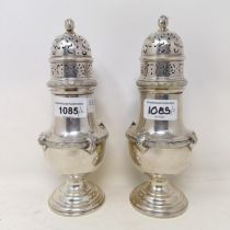 A pair of 18th century style silver sugar casters, with flowerhead finials, Birmingham 1925, 26.6