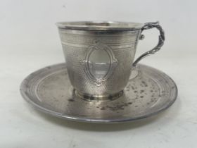 A late 19th century Continental silver coloured metal cup and saucer, with engine turned