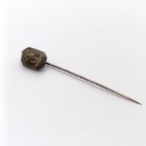 A 20th century silver coloured metal stick pin, inset with lava stone cameo, decorated lady