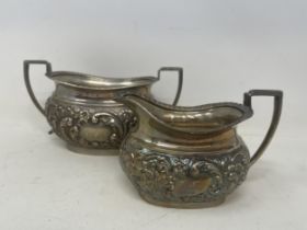 An Edwardian silver sugar bowl, initialed, and with embossed decoration, with a matching milk jug,