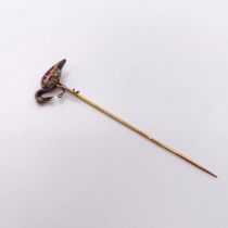 A late 19th/early 20th century yellow metal, red and white stone stick pin, in the form of a bird