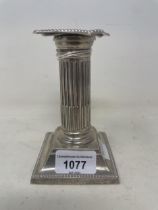 An Edward VII silver squat candlestick, in the form of a column, Birmingham 1902, base filled