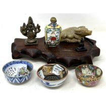 A Chinese snuff bottle, 6 cm high, three tea bowls, a carved bull, a bronze figure and a stand (box)