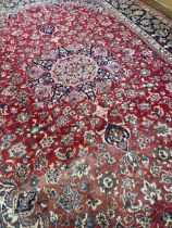 A Persian style red ground carpet, 390 x 297 cm Faded, some holes