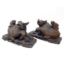 A pair of Chinese carvings of oxen, with figures on their backs, 30 cm wide (2)