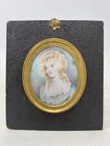 A portrait miniature, of a young lady in a blue dress, oil on board, 12 x 9 cm, in an ebonised and