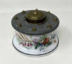 A 19th century porcelain and brass inkstand, A T & C patent, decorated flowers, 9 cm diameter