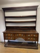 An 18th century oak dresser, with a three tier plate rack, on a base with five drawers above an