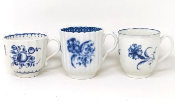 An early Worcester blue and white cup, decorated flowers, 6 cm diameter, and two other cups (3)