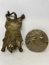 A brass pin tray, in the form of a lion skin, and a plaque (2)