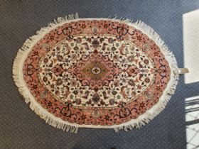 A Tabriz Persian oval cream ground rug, 142 x 104 cm Large losses to fringe, general wear