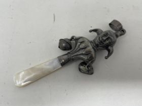 A silver and mother of pearl rattle, in the form of a jester