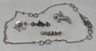 A silver brooch, in the form of a horse and jockey, three other silver brooches, and a silver