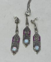 A silver, ruby and opal Art Deco style pendant, on a chain, and matching earrings (3) Condition