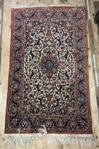 A Persian cream ground rug, with multiple borders, the centre with a shaped medallion and
