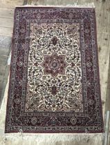 A Persian cream ground rug, with multiple borders, the centre with concentric shaped medallions,