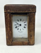 A carriage clock, by Mappin & Webb, London, in a brass and glass case, 14 cm high, with a leather