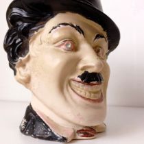 An unusual character jug, in the form of Charlie Chaplin, 23 cm high, handle repaired