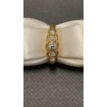 An 18 carat yellow gold ring set with 5 diamonds. Middle diamond 0.20 carat, size L, 2.8 grams
