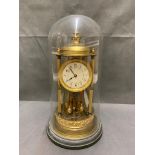 Antique anniversary clock with enamel face under glass dome