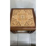 A mid century nest of coffee tables with tiled top