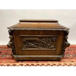 An antique oak chest with a heavily carved nativity scene to the front, carved cherubs to the