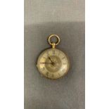 An 18 carat gold ladies fob watch, with a silver face, in need of a service, presently not