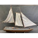 An antique wooden model sailing boat on stand