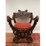 A Savonarola Chair, possibly oak heavily carved chair, nineteenth century, with upholstered seat