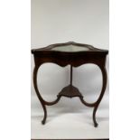 An Edwardian triangular mahogany vitrine