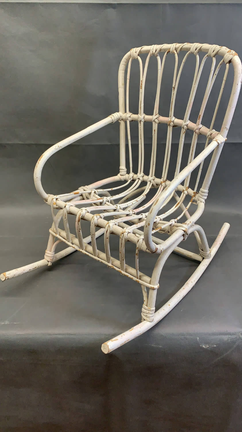 A small vintage cane child's rocking chair