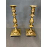 A pair of solid brass antique candlesticks, 24cm high