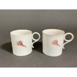 Two possibly Capodimonte or Naples coffee cups with the Caduceus symbol and sparse floral