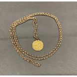 A 1889 full sovereign in 9 carat gold mount and chain, 29.6 grams, chain not hallmarked but tests