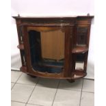 An antique wall cabinet with glazed front and mirrored back