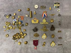 A collection of military cap badges and buttons