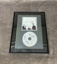 A framed signed photo and cd by U2 Frame Size 29 x 37cm