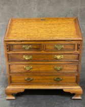 A miniature oak apprentice made bureau with all round dovetails joints