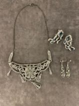 An antique white metal necklace along with two pairs of white metal earrings