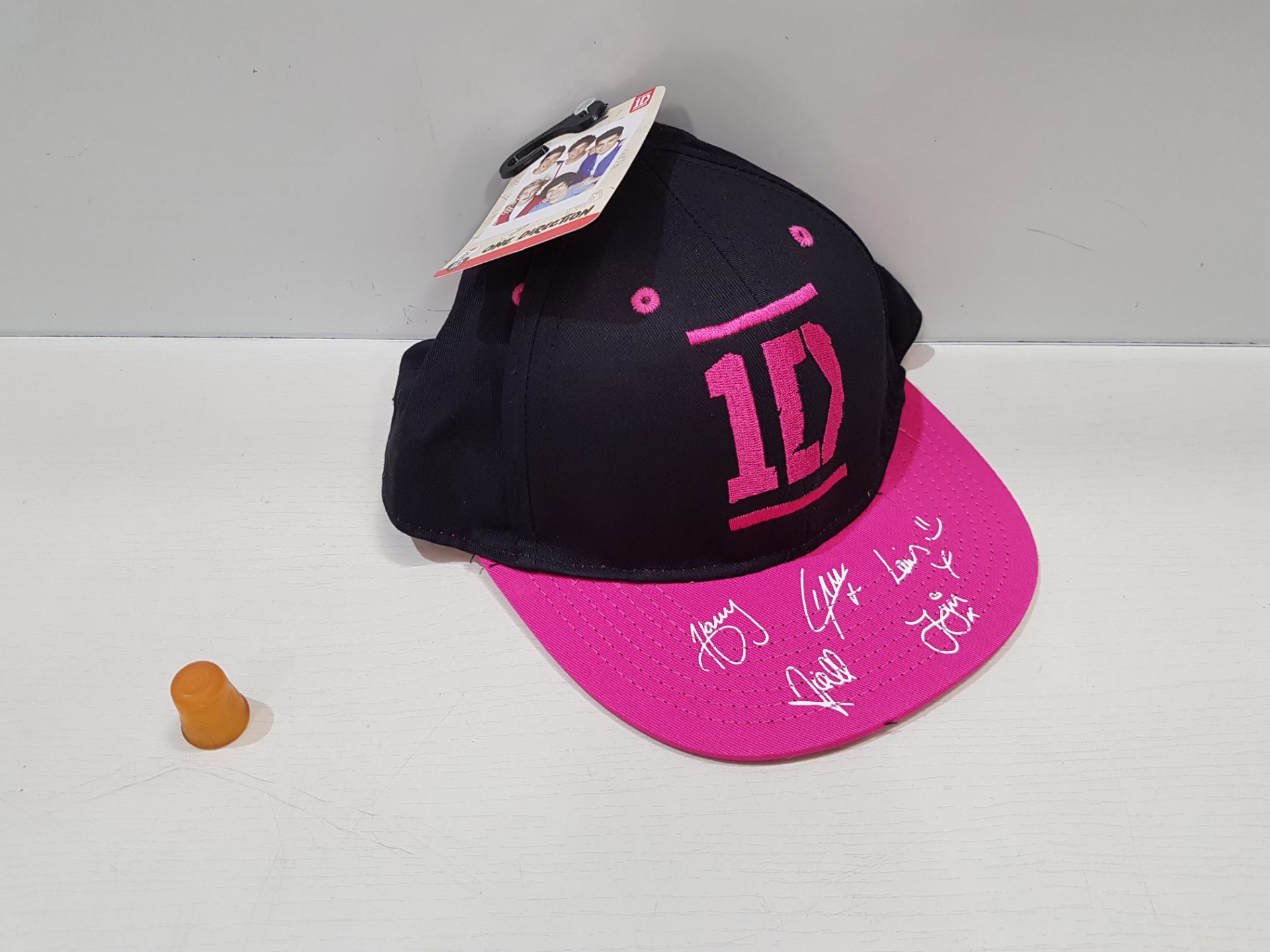 45 X BRAND NEW 1 DIRECTION SIGNED PRINT STYLE HATS IN BLACK AND PINK (ALL IN SIZE 7 TO 12 YEARS)