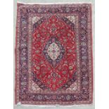 A Persian Kashan woollen hand knotted rug, the central medallion with floral sprays and borders,