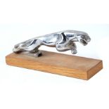 A Jaguar car mascot mounted on a wooden plinth, 18cms long.