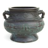 A large Japanese bronze twin-handled censer with archaic style decoration, 25cms wide.