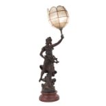 A spelter figural lamp in the form of a maiden holding a torch aloft, mounted on a wooden base,