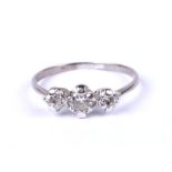 A white metal three stone diamond ring. Approx UK size P. 1.2g