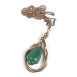 A yellow metal mounted pendant with green stone drop in the form of an entwined snake, on a chain.