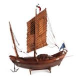 A Chinese wooden model of a junk on a stand, 43cms long.